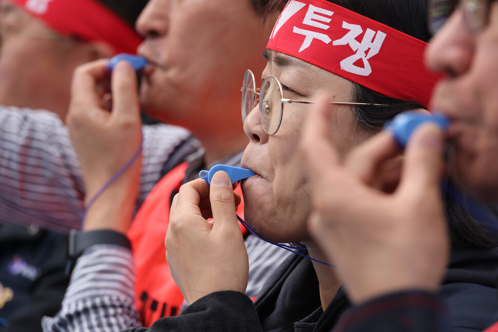 민주노총 집회 참가 노동자들이 25일 오후 4시가 되자 일제히 호루라기를 불고 있다.