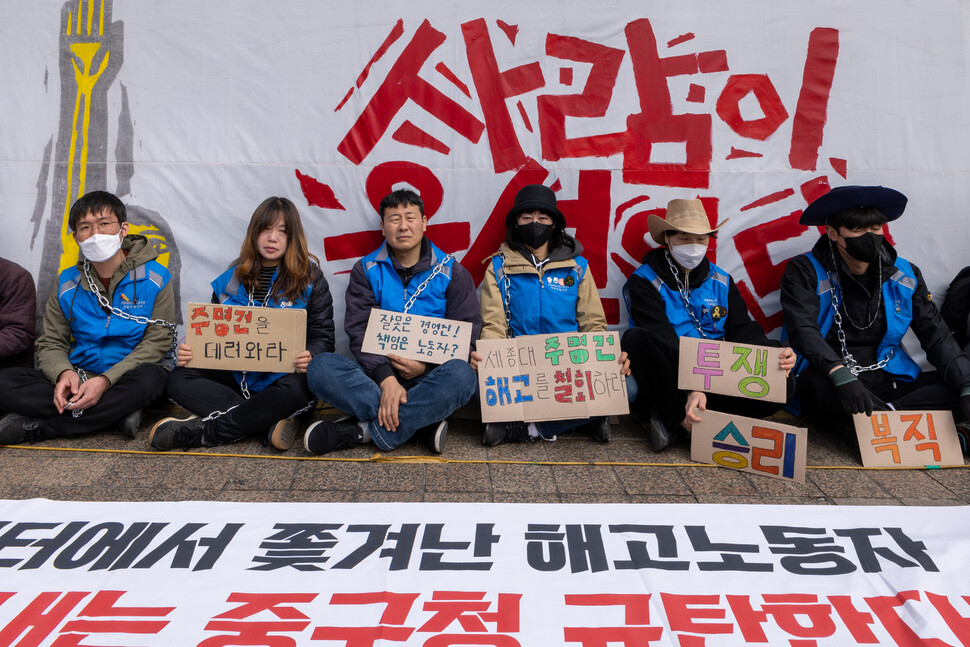 세종호텔 해고노동자들이 3월24일 오전 서울 중구 세종호텔 앞 천막농성장에서 중구청의 기습 철거에 대비해 쇠사슬로 몸을 묶은 채 팻말시위를 벌이고 있다.