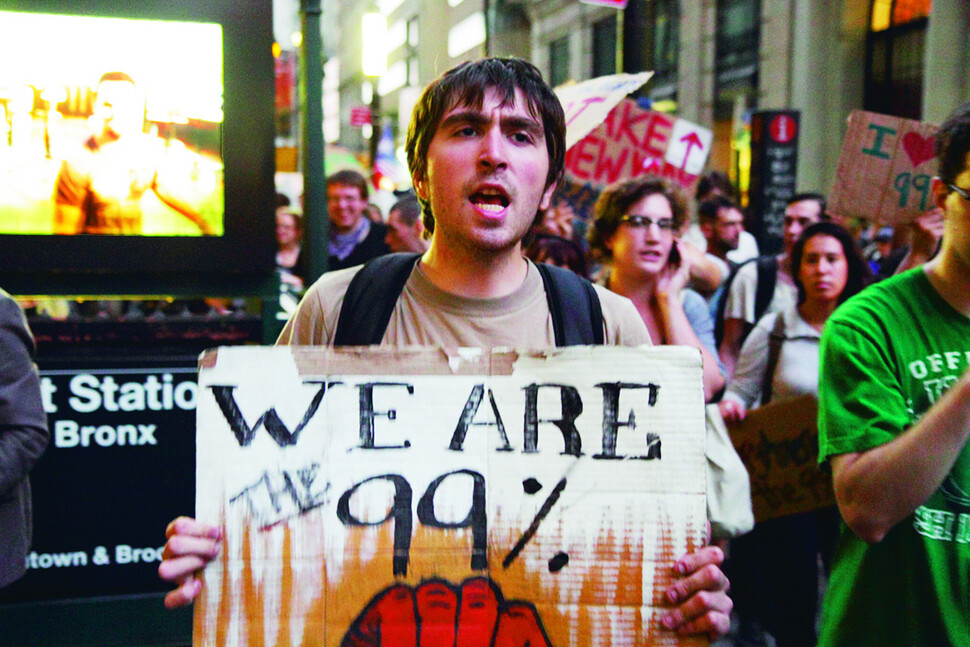 2011년 9월 미국 뉴욕의 금융 중심지 월스트리트에서 극단적인 빈부격차와 금융자본의 탐욕에 항의해 벌어진 ‘오큐파이(점령하라) 운동’에 참가한 한 시민이 “우리가 99%다”라는 구호를 적은 종이를 들어 보이고 있다. 출처 위키미디어 코먼스