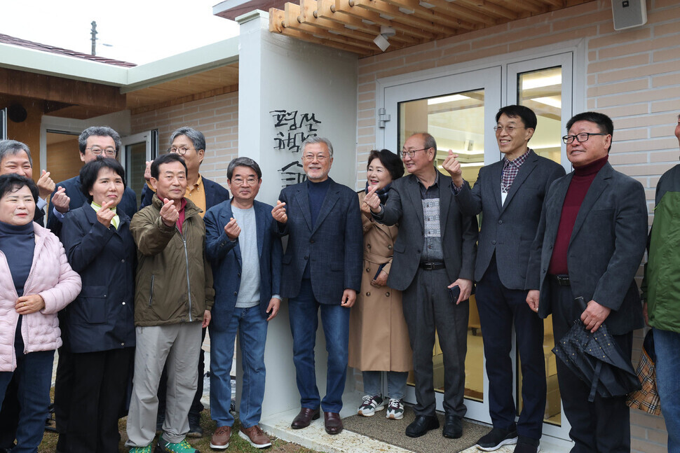 Moon and village residents pose for a photo after the unveiling of the sign for the former president’s bookshop in Pyeongsan, a village in the South Gyeongsang Province city of Yangsan on April 25. (Baek So-ah/The Hankyoreh)