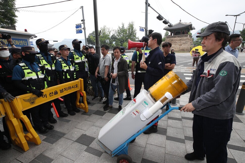 Activists attempted to deliver a water cooler modified to look as though it carries irradiated water from the Fukushima nuclear disaster to the Japanese Embassy in Seoul on June 7, but were stopped by police. (Kim Bong-gyu/The Hankyoreh)