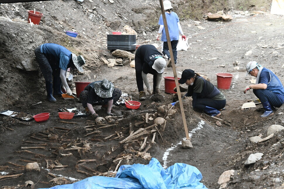 Members of the excavation team exhume human remains from the site of the Gollyeong Valley massacre on Aug. 6, 2021. (courtesy of the excavation team)