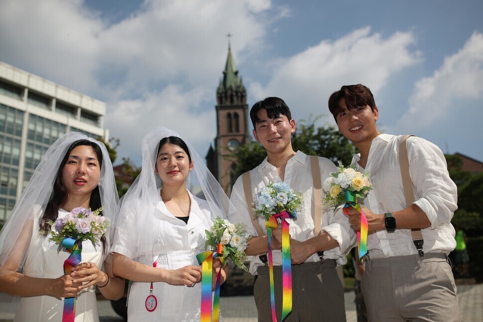 Kim Se-yeon and Kim Kyu-jin, a lesbian couple, pose with Kim and Pack, a gay couple, outside Myeongdong Cathedral in Seoul on July 1. (Kim Bong-gyu/The Hankyoreh)