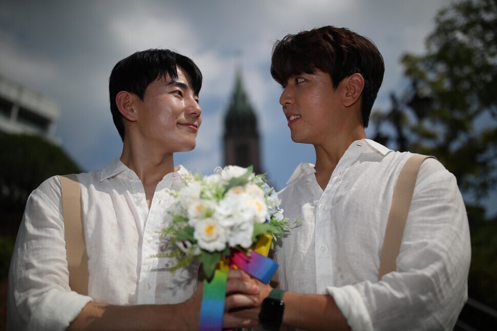 Kim and Pack, who have been together for a decade, pose together outside Myeongdong Cathedral on July 1, the day of Seoul’s Pride event. (Kim Bong-gyu/The Hankyoreh)