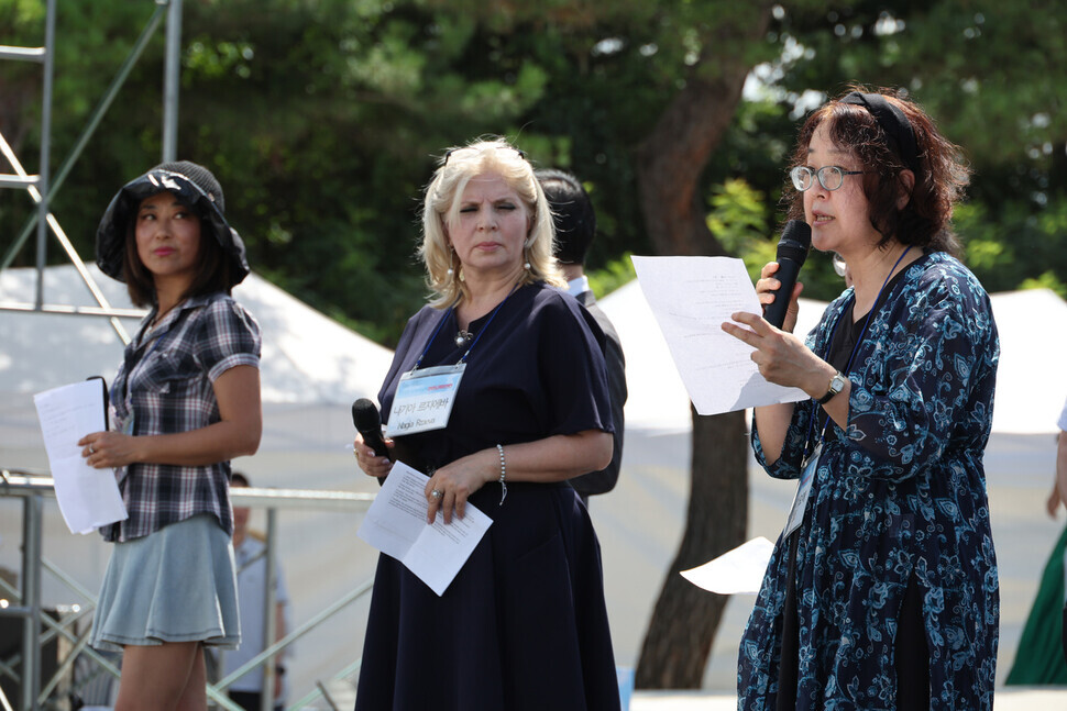 Kiyoe Kawazu, a Japanese poet, speaks for peace in Korea alongside New Zealand painter/poet Sue Zhu and Azerbaijan artist Nagia Rzaeva in Paju on July 27. (Kim Hye-yun/The Hankyoreh)