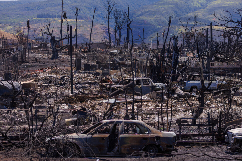 초대형 산불이 발생한 지 일주일 뒤인 2023년 8월15일 미국 하와이주 마우이섬 북서부 라하이나 지역에서 불타버린 건물과 차량 잔해가 방치돼 있다. 로이터 연합뉴스