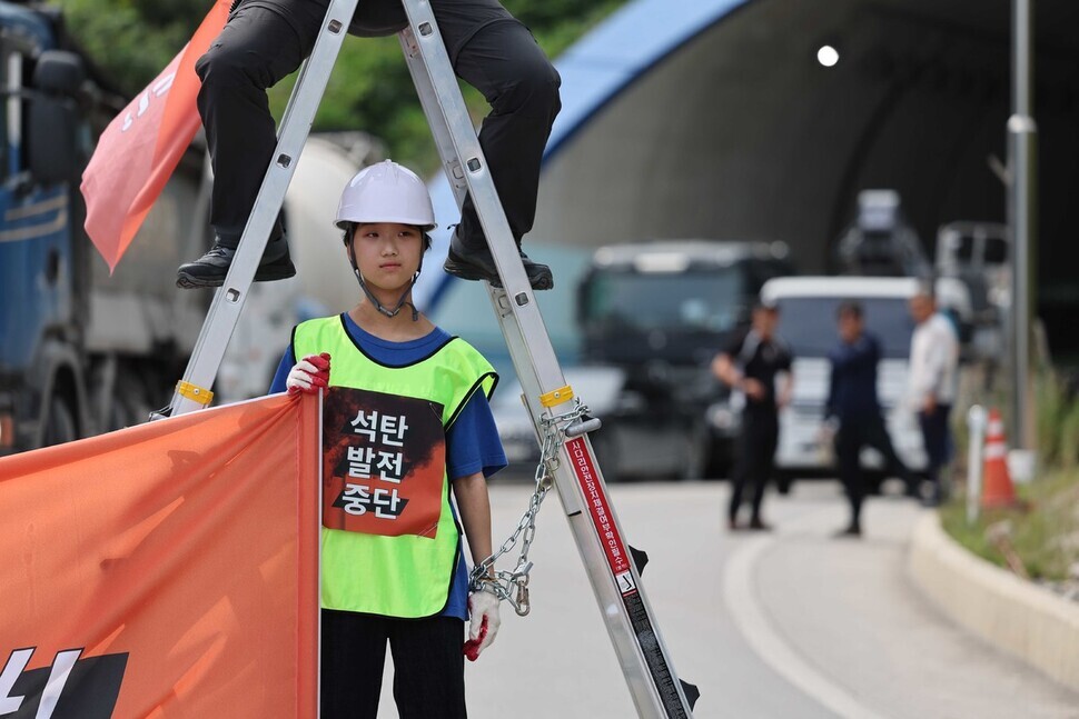 Korean environmental activists occupied a road leading to a coal power station being built by Samcheok Blue Power in Samcheok, Gangwon Province, where some protestors chained themselves to ladders that others sat atop. (Park Jong-shik/The Hankyoreh)