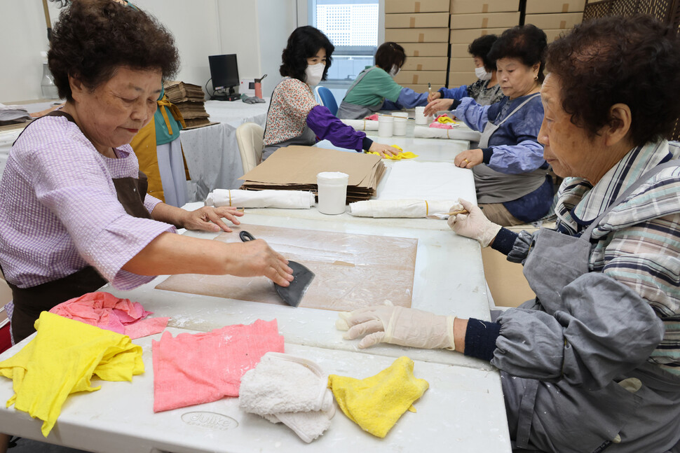 사회적기업 ‘러블리페이퍼’(LOVE RE:PAPER)가 고용한 어르신 직원들이 쌀포대에 버려진 천을 붙여 종이가죽을 만들고 있다.