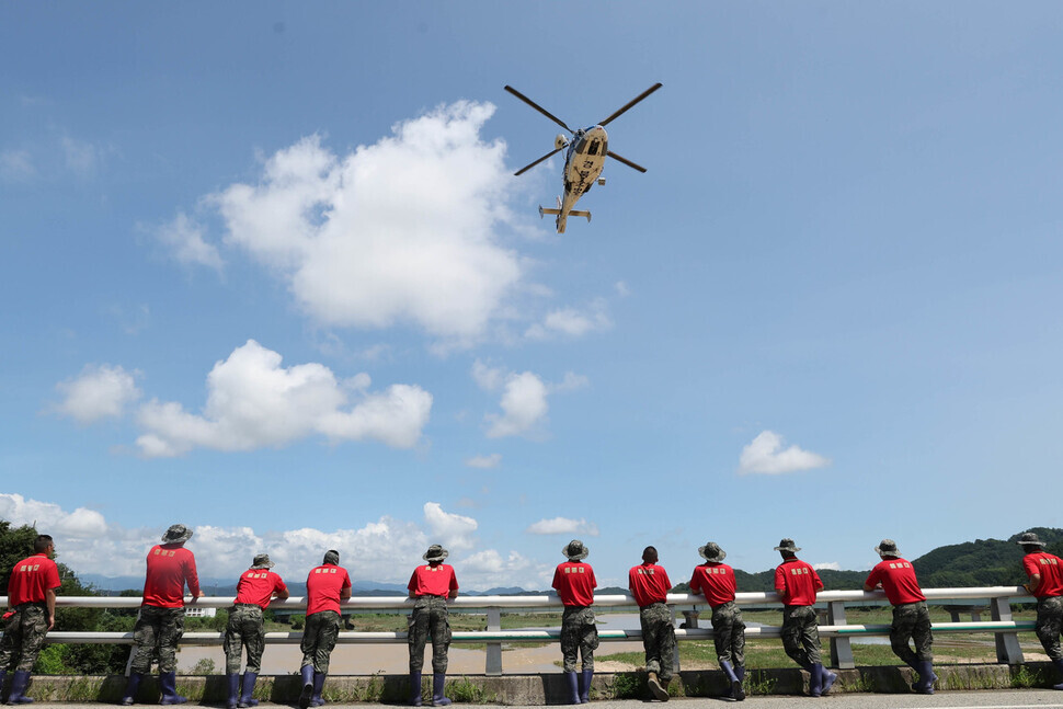 Firefighters mobilize a helicopter and boats to search for a Marine who was swept up in floodwaters in North Gyeongsang Province’s Yecheon County on July 19. (Baek So-ah/The Hankyoreh)