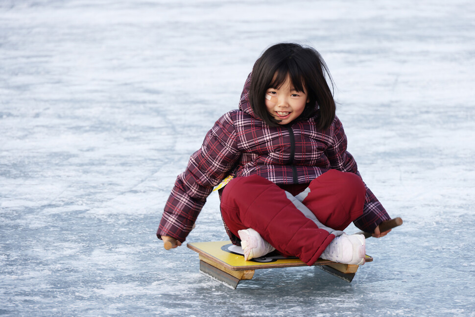 2024년 1월10일 오후 강원도 화천군에서 열리는 ‘얼음나라화천 산천어축제’ 썰매장에서 한 어린이가 얼음을 지치고 있다.