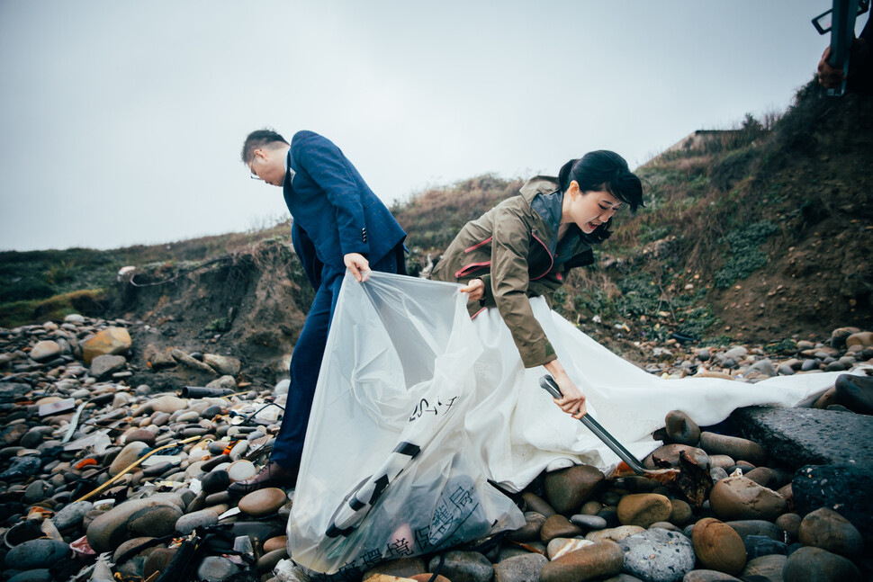 2024년 1월20일 ‘친환경 결혼식’을 한 이안 시오우(왼쪽)와 아이리스 슈에 부부가 결혼식 마지막 순서인 해변 정화 활동을 하고 있다.