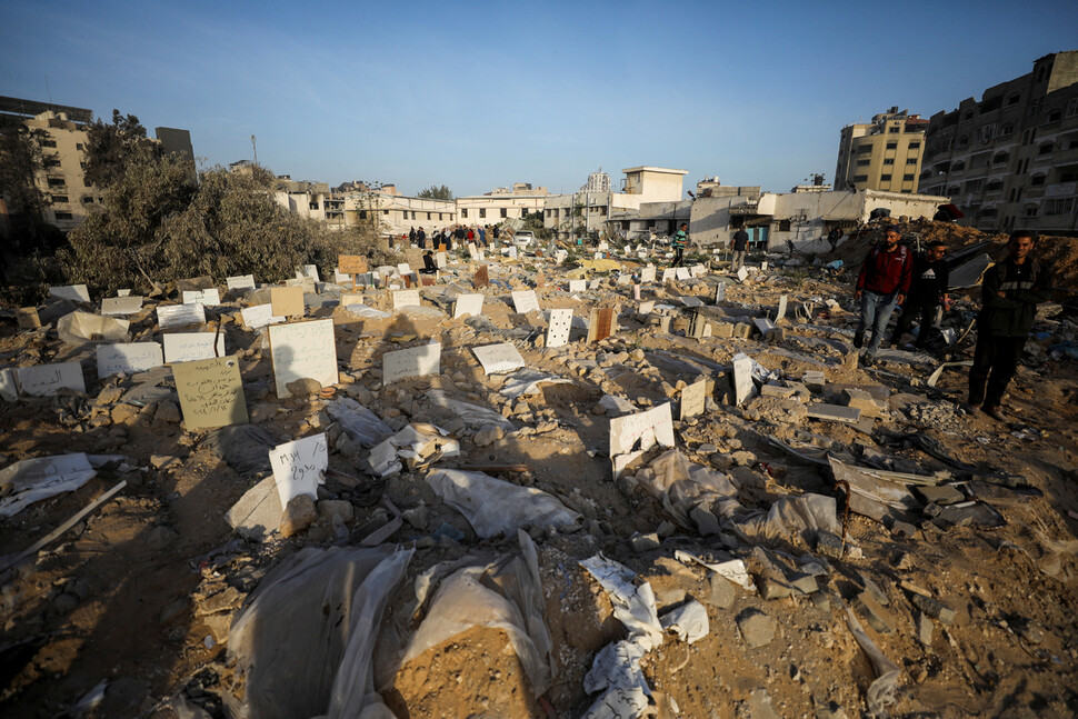 이스라엘군이 2주간의 봉쇄 작전을 마친 뒤 물러간 팔레스타인 땅 가자지구 알시파병원 곁 공동묘지에서 주민들이 훼손된 무덤을 살피고 있다. REUTERS 연합뉴스