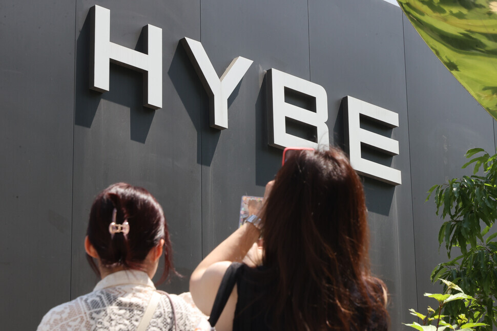 People snap photos outside Hybe’s headquarters in Seoul’s Yongsan District. (Yonhap)