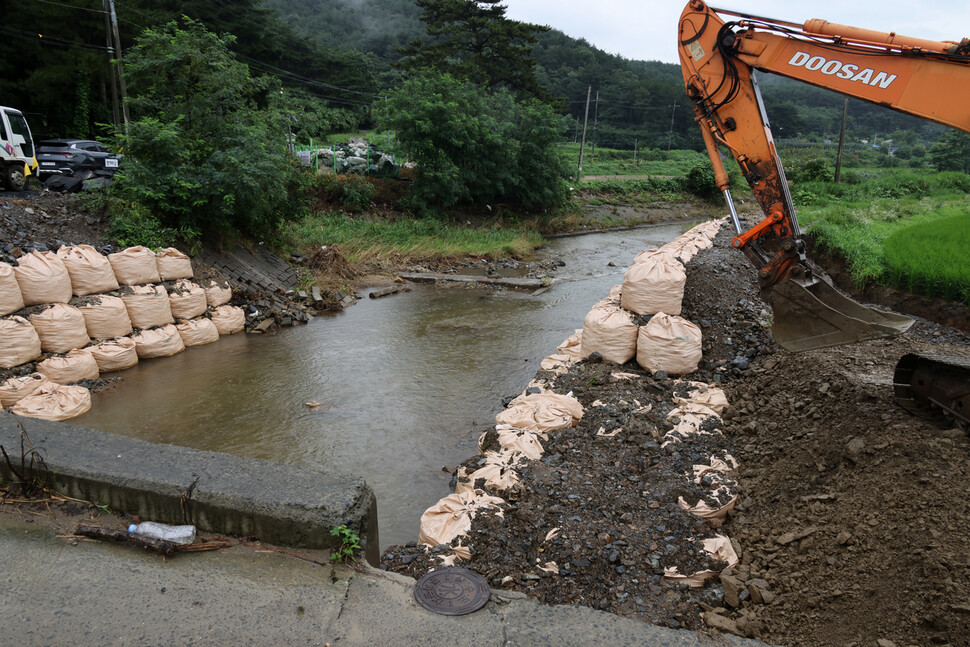 7월23일, 2주 전 새벽 내린 강한 비로 끊어진 충남 서천군 비인면 도로의 복구 작업을 하고 있다. 류우종 기자