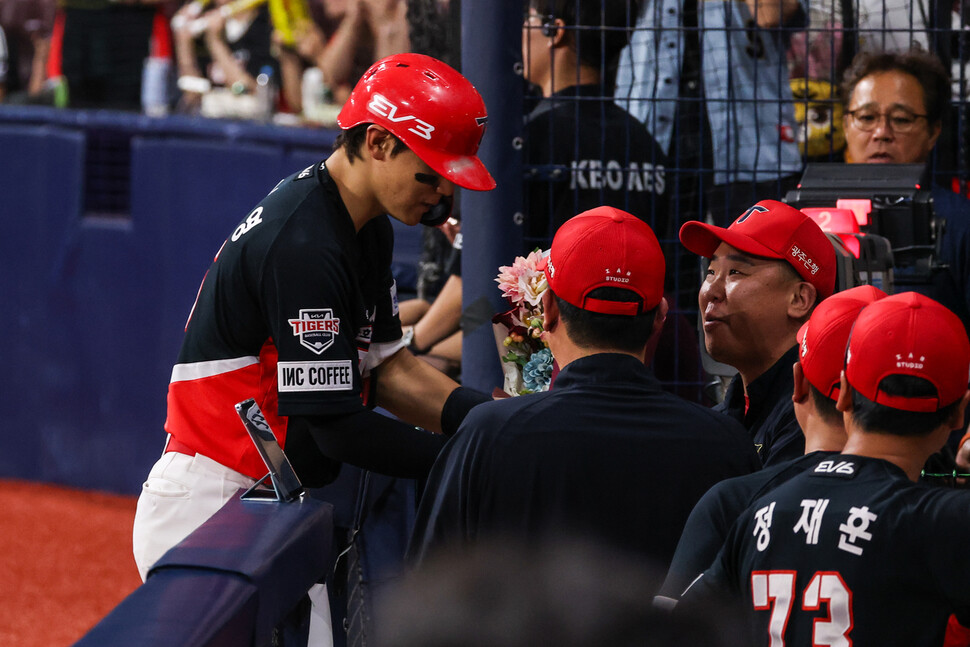 Kim Do-young dos KIA Tigers recebe um buquê de flores do gerente da KIA, Lee Beom-ho, no banco de reservas depois de acertar um home run de 30 e 30 bases roubadas com um home run no topo do quinto inning em uma Liga KBO de 2024 Jogo Kiwoom Heroes realizado no Gocheok Sky Dome em Guro-gu, Seul, no dia 15. Apresentado por Kia Tigers