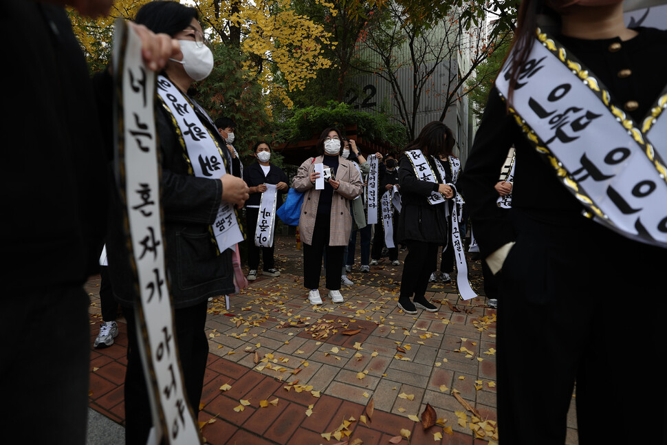 자녀가 학교폭력에 가담한 것으로 지목된 이영경 경기도 성남시의회 시의원의 사퇴와 제명을 촉구하는 성남시 분당 ‘학폭 아웃, 피해자 보호 가해자 엄벌, 학폭 문제 해결합시다' 오픈 카톡방 모임 학부모들이 2024년 10월29일 이 시의원이 학교운영위원장을 맡은 한 중학교 들머리에서 근조 화환에서 떼어 온 리본을 목에 두르고 있다.