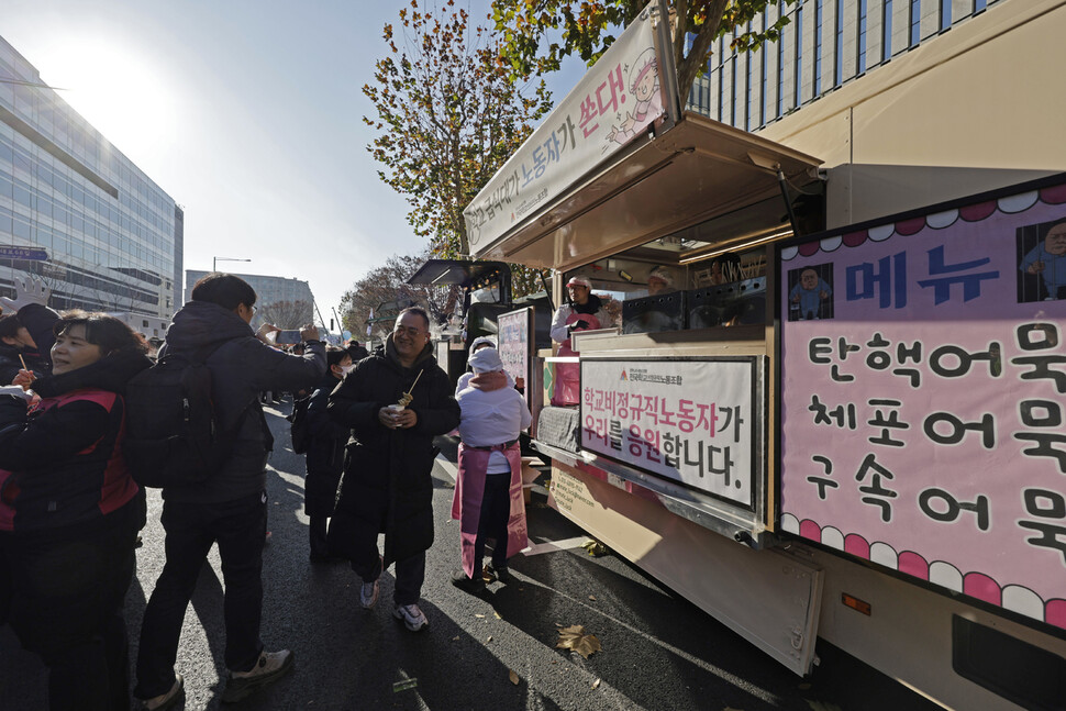 12·3 내란 우두머리인 대통령 윤석열에 대한 탄핵소추안이 국회에서 가결된 2024년 12월14일 오후 국회 앞에서 학교 비정규직인 급식노동자들이 시민들에게 어묵을 나눠주고 있다. 김명진 기자