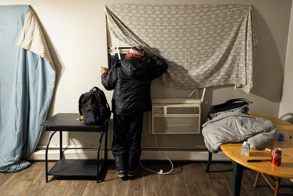 2025년 1월30일 미국 콜로라도주 오로라의 아파트에서 베네수엘라 출신 이민자가 짐 가방을 곁에 두고 창밖을 살피고 있다.