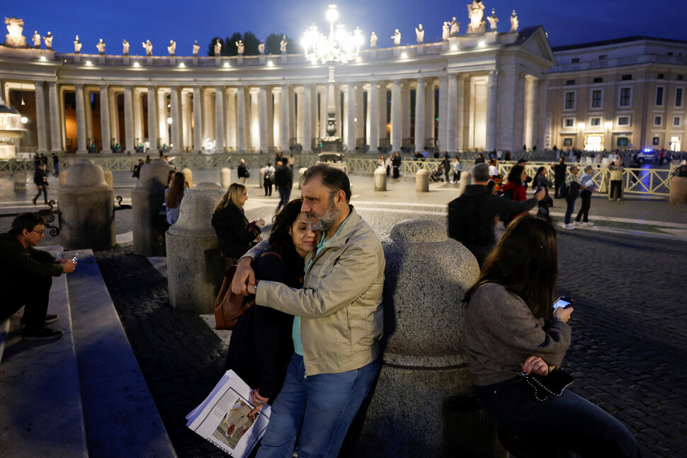 21일(현지시각) 바티칸 성 베드로 광장에서 교황 선종 후 프란치스코 교황을 위한 묵주기도를 마친 신도들이 포옹하고 있다. 로이터 연합뉴스