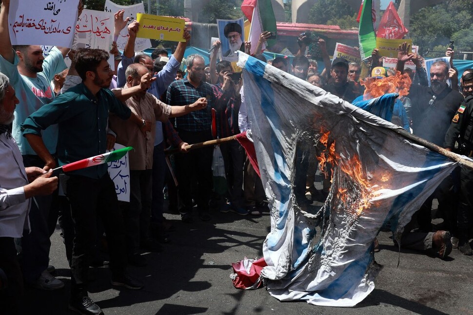 이스라엘이 이란 침공을 감행한 지 8일째 되는 2025년 6월20일, 이란 시민들이 테헤란에서 이스라엘을 규탄하며 미국과 이스라엘 국기를 불태우고 있다. AFP 연합뉴스