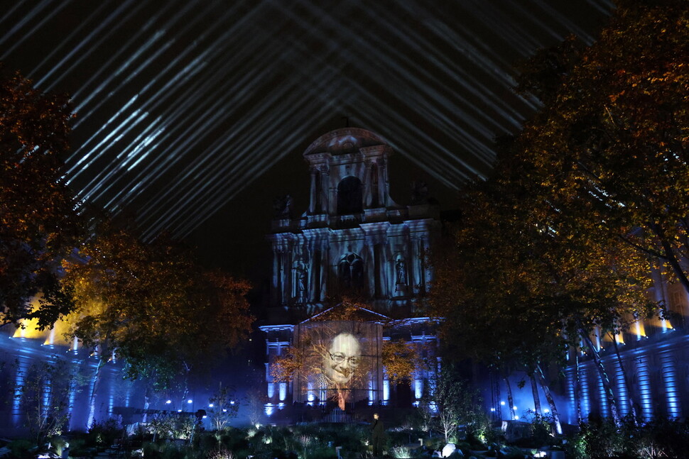 13일(현지시각) 파리에서 열린 파리 테러 10주기 추모 행사에서 희생자들의 사진이 건물 벽면에 투사되고 있다. 파리/EPA 연합뉴스