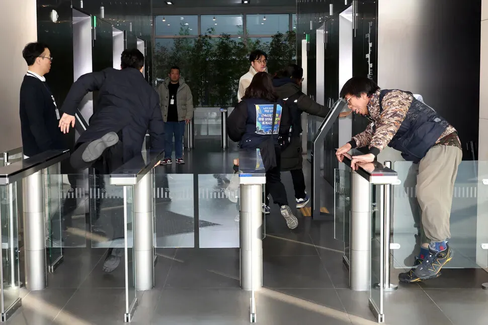 Members of the Coupang distribution center union jump the speed gates outside the elevators at the company’s headquarters in Seoul to attempt to speak to the CEO on Dec. 10, 2025. (Kim Young-won/Hankyoreh)
