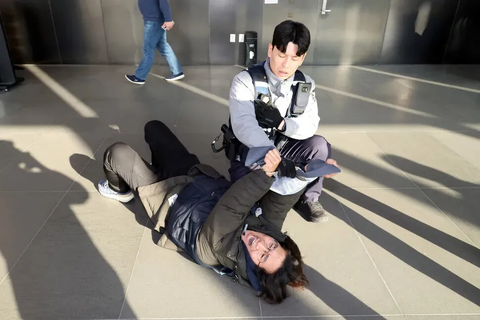 Police arrest members of the Coupang distribution center union after they jumped gates and attempted to speak to CEO Park Dae-jun during a surprise demonstration at the e-commerce giant’s headquarters in Seoul’s Songpa District on Dec. 10, 2025. (Kim Young-won/Hankyoreh)