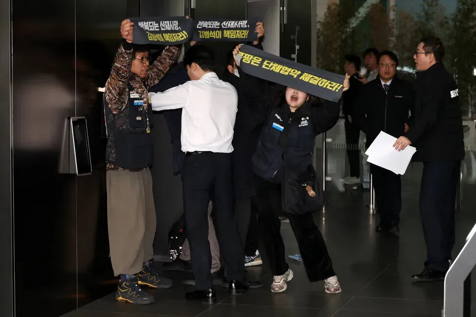 Members of the Coupang distribution center union hold up banners during a surprise demonstration at the company’s headquarters on Dec. 10, 2025. (Kim Young-won/Hankyoreh)