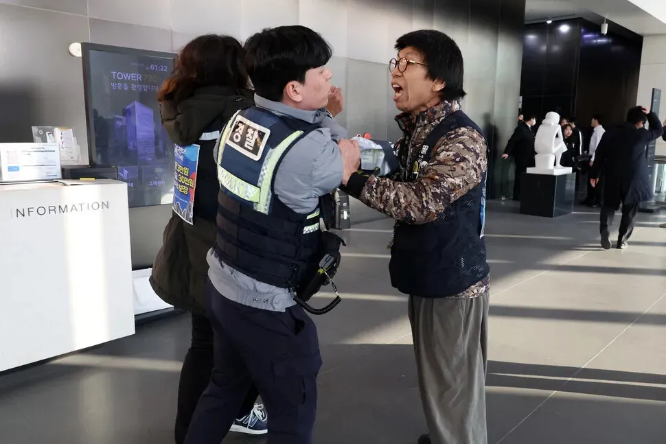 Police arrest members of the Coupang distribution center union after they jumped gates and attempted to speak to CEO Park Dae-jun during a surprise demonstration at the e-commerce giant’s headquarters in Seoul’s Songpa District on Dec. 10, 2025. (Kim Young-won/Hankyoreh)