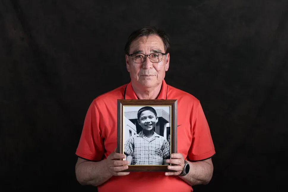 Cho Young-il holds up a photo taken by his foster family when he was around the age of 7 or 8. Holt had arranged for him to be sent to a family in Sweden in 1964, only for his adoption to be canceled when he arrived at the airport. His mixed-race background as an adoptee made life for both him and his family more challenging. (Kim Young-won/Hankyoreh)