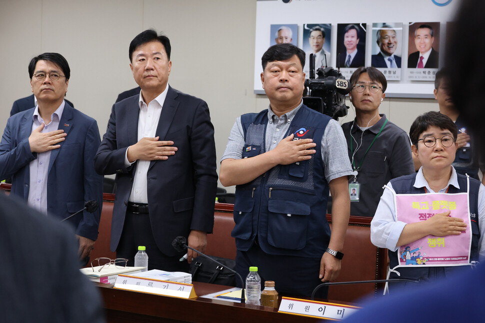 9일 정부세종청사 최저임금위원회에서 열린 제4차 전원회의에서 근로자위원과 사용자위원들이 국기에 경례하고 있다. 왼쪽부터 양옥석 중소기업중앙회 인력정책본부장, 류기정 한국경영자총협회(경총) 전무, 류기섭 한국노총 사무총장, 민주노총 이미선 부위원장.연합뉴스
