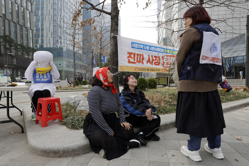 강명지(머리에 두건을 두른 이)씨와 ‘말벌 동지들’이 2025년 3월25일 당시 고공농성 중이던 김형수 거제·통영·고성 조선하청지회장을 응원하기 위해 서울 중구 한화빌딩 앞을 찾아 대화하고 있는 모습. 김명진 기자