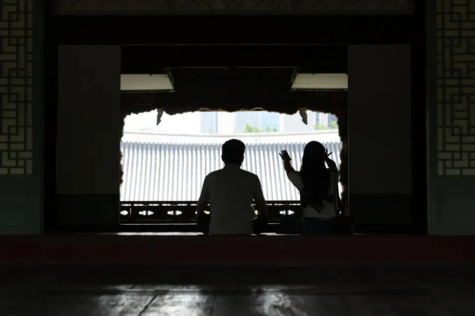 Two palace-goers enjoy their perch at Gyeonghoe Pavilion (Gyeonghoeru) at Gyeongbok Palace on Sept. 2, 2026. (Choi Hyeon-su/Hankyoreh)