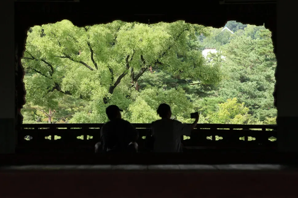 Two palace-goers snap a picture while on a special tour of Gyeonghoe Pavilion (Gyeonghoeru) at Gyeongbok Palace on Sept. 2, 2026. (Choi Hyeon-su/Hankyoreh)