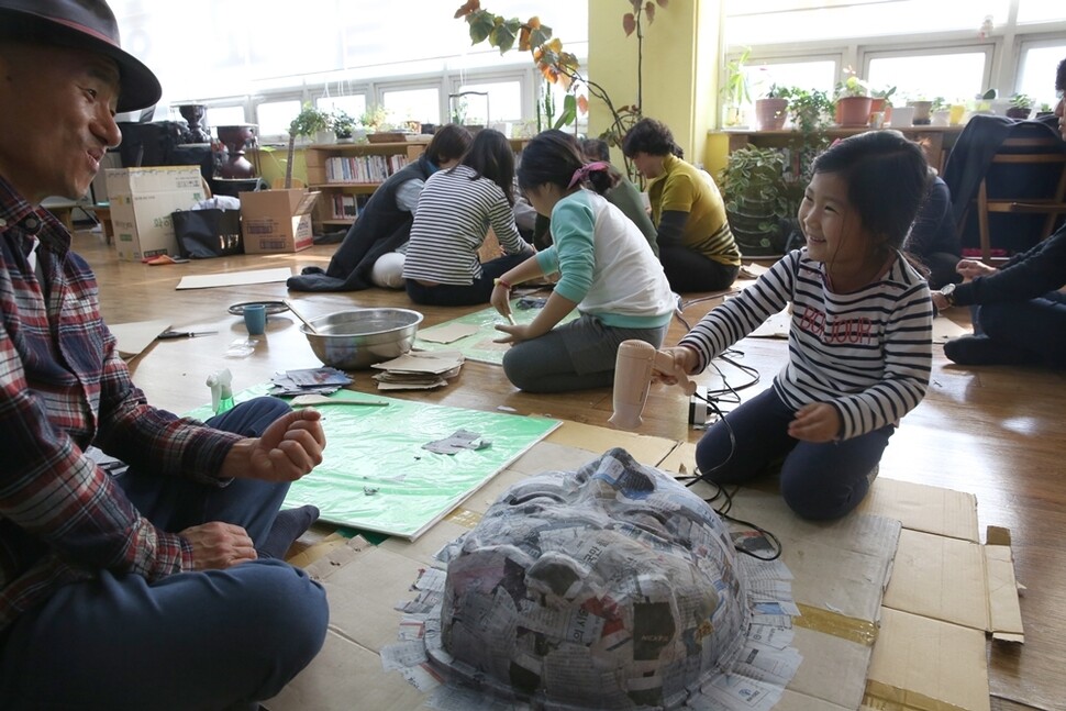 경기도 일산 동녘교회에서 한 아이가 헤어드라이어의 따뜻한 바람으로 종이탈을 말리고 있다.