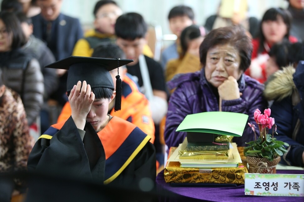 추산초등학교 졸업식에서 조영성 졸업생의 할머니가 눈물을 닦는 손자를 보며 안쓰러워하고 있다.
