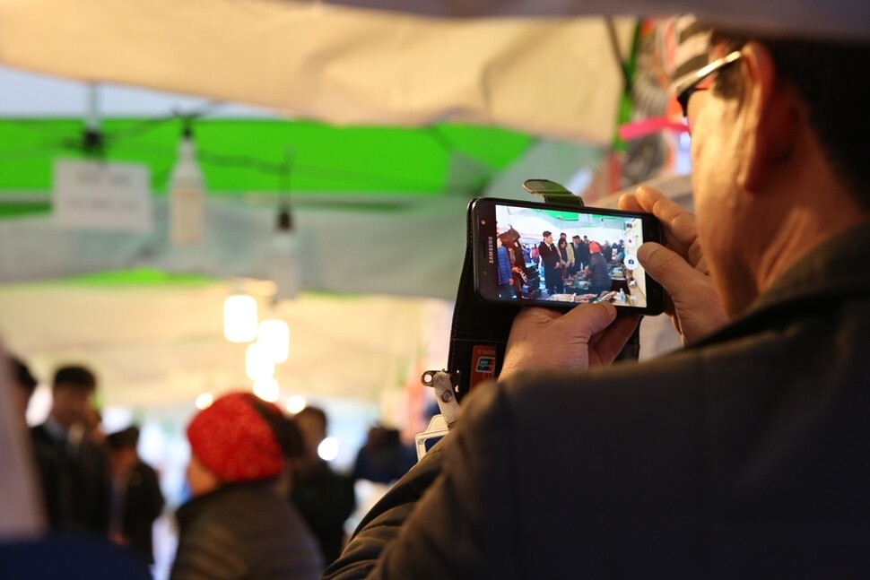 2월28일 여수 수산시장에서 이재명 시장 지지자가 스마트폰으로 촬영하고 있다.