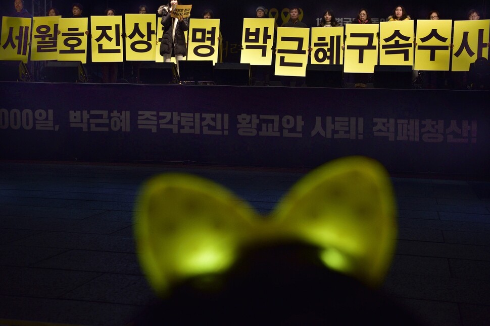 Participants hold placards calling for a thorough investigation into the Sewol ferry sinking and the arrest of Park Geun-hye