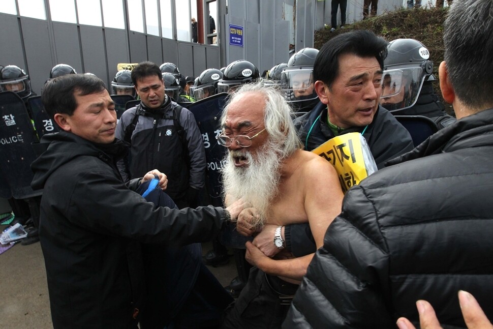 제주해군기지 건설을 위한 구럼비 바위 발파 공사를 두고 주민과 시민단체, 정부가 정면 충돌 양상을 보였다. 2012년 3월8일 오전 강정마을 해군기지 건설 현장 앞에서 윗옷을 벗고 항의시위를 하던 문정현 신부(가운데)가 오열하고 있다.
