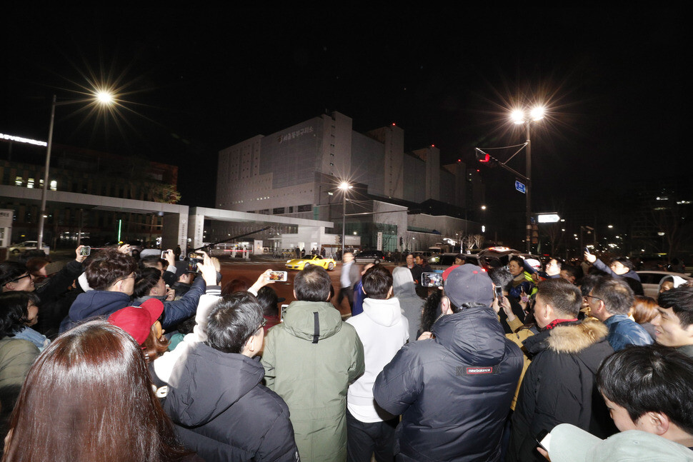 A group of citizens watch former president Lee Myung-bak being taken into Seoul Eastern District Detention Center in the Songpa district of Seoul on Mar. 23. (by Lee Jung-ah