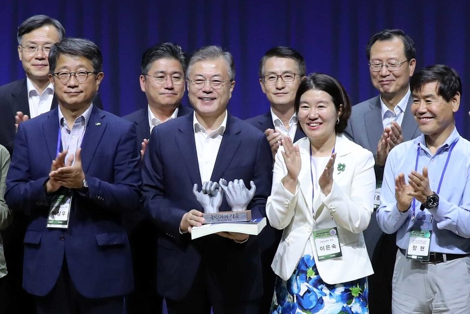 South Korean President Moon Jae-in poses with attendees of a workshop for innovating the public sector at the National Health Insurance Office in Wonju