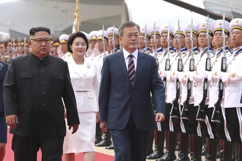 South Korean President Moon Jae-in and North Korea leader Kim Jong-un review the honor guard at Pyongyang Sunan International airport during Moon’s welcome ceremony for the inter-Korean summit on Sept. 19. North Korean first lady Ri Sol-ju is seen behind Moon. (photo pool)


