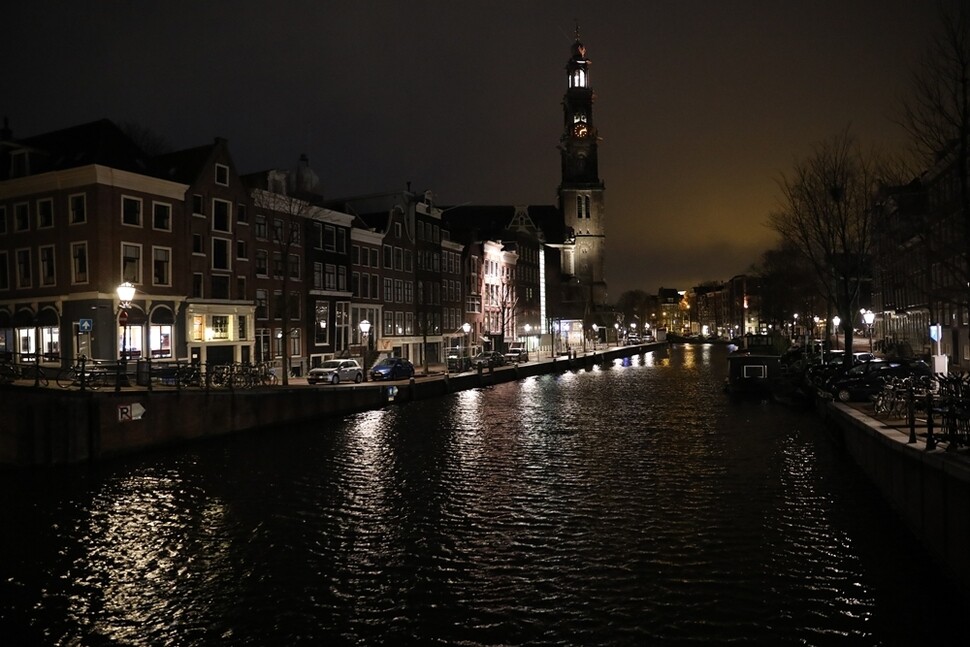 안네 프랑크 가족이 숨어 지냈던 네덜란드 암스테르담의 은신처 건물(불이 밝혀진 창문)과 수로. 바로 옆에 교회 종탑이 있다.