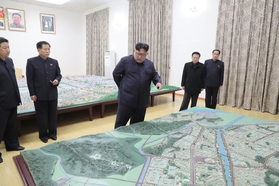 North Korean leader Kim Jong-un inspecting plans for a development project in Sinuiju