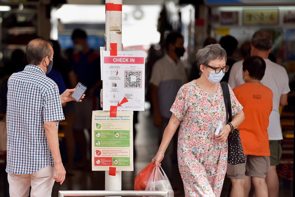 싱가포르 시민들이 지난 3일 스마트폰 인증 뒤, 식당가로 들어가고 있다. 로이터 연합뉴스