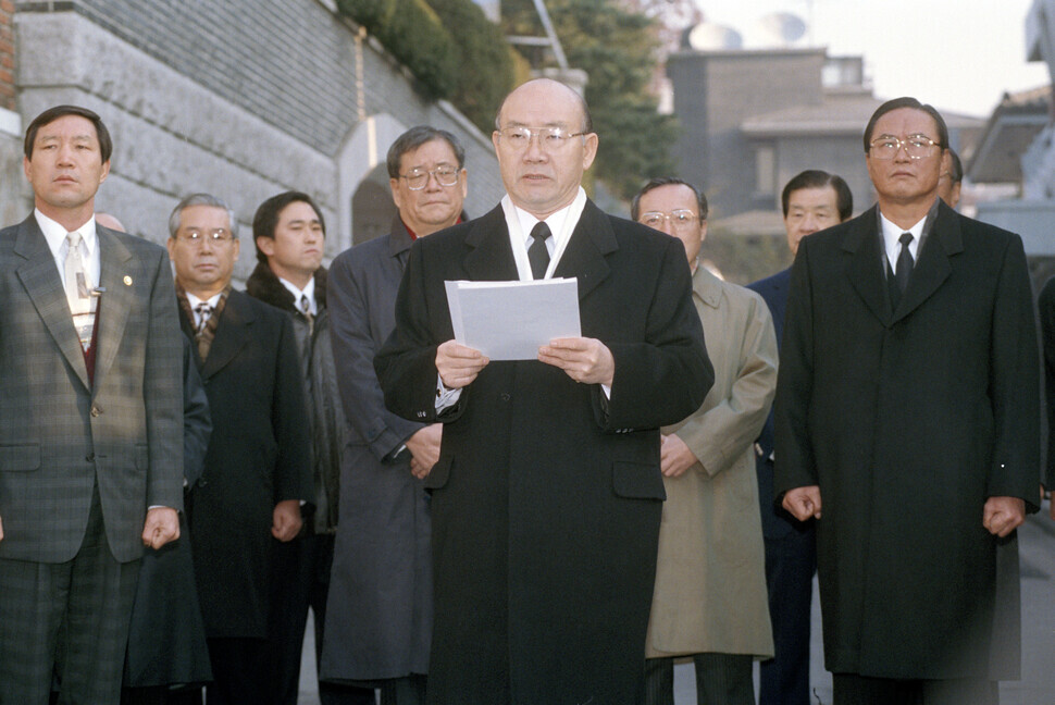 Standing in an alleyway in front of his Yeonhui neighborhood home, Chun addresses the nation on Dec. 2, 1995, reading a two-page statement on his refusal to comply with a subpoena by prosecutors. After finishing his statement, Chun went to his hometown of Hapcheon County where he held out until being taken into custody. (Yonhap News)