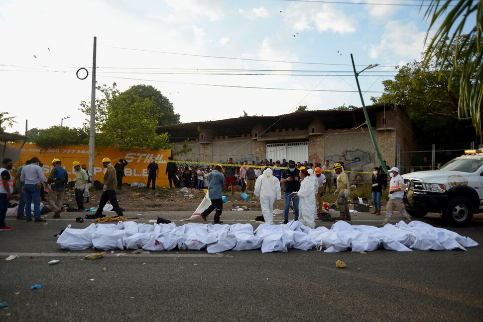 멕시코 치아파스주 툭스틀라 구티에레스에서 발생한 이민자 수송 화물트럭 전복사고 현장에 희생자들의 시신이 하얀 천에 덮인 채 수습돼 있다. 툭스틀라 구티에레스/로이터 연합뉴스