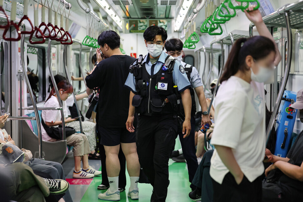 Security officers with the Seoul Metro patrol a Line 2 train at Dangsan Station on Aug. 20 after on Aug. 19 an armed man injured passengers on a Line 2 train. To step up their security presence, the Seoul Metro is having 55 security officers carrying tear gas guns patrol trains in pairs. (Yonhap)