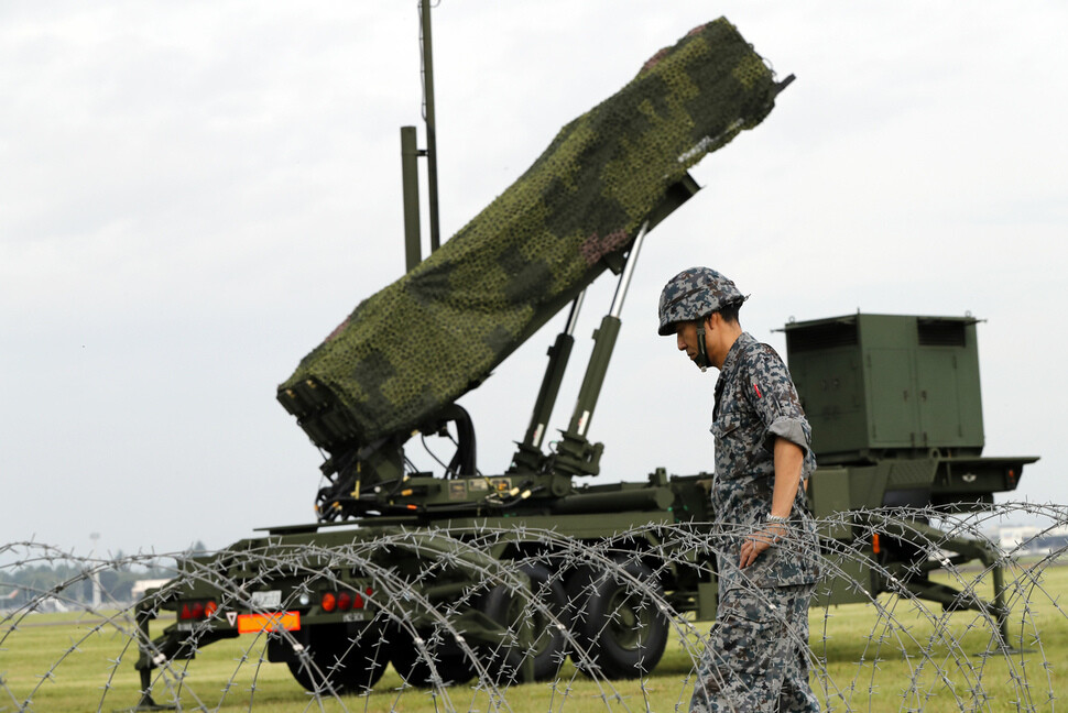 A member of the Japanese Self-Defense Forces stands in front of a Patriot-3 missile launcher at Yokota Air Base in Tokyo.  (Tokyo/AP)