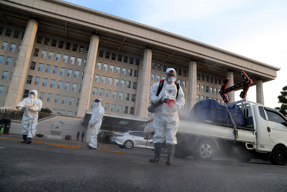 Health workers disinfect National Assembly facilities on Feb. 24. (Kim Gyoung-ho, senior staff writer)